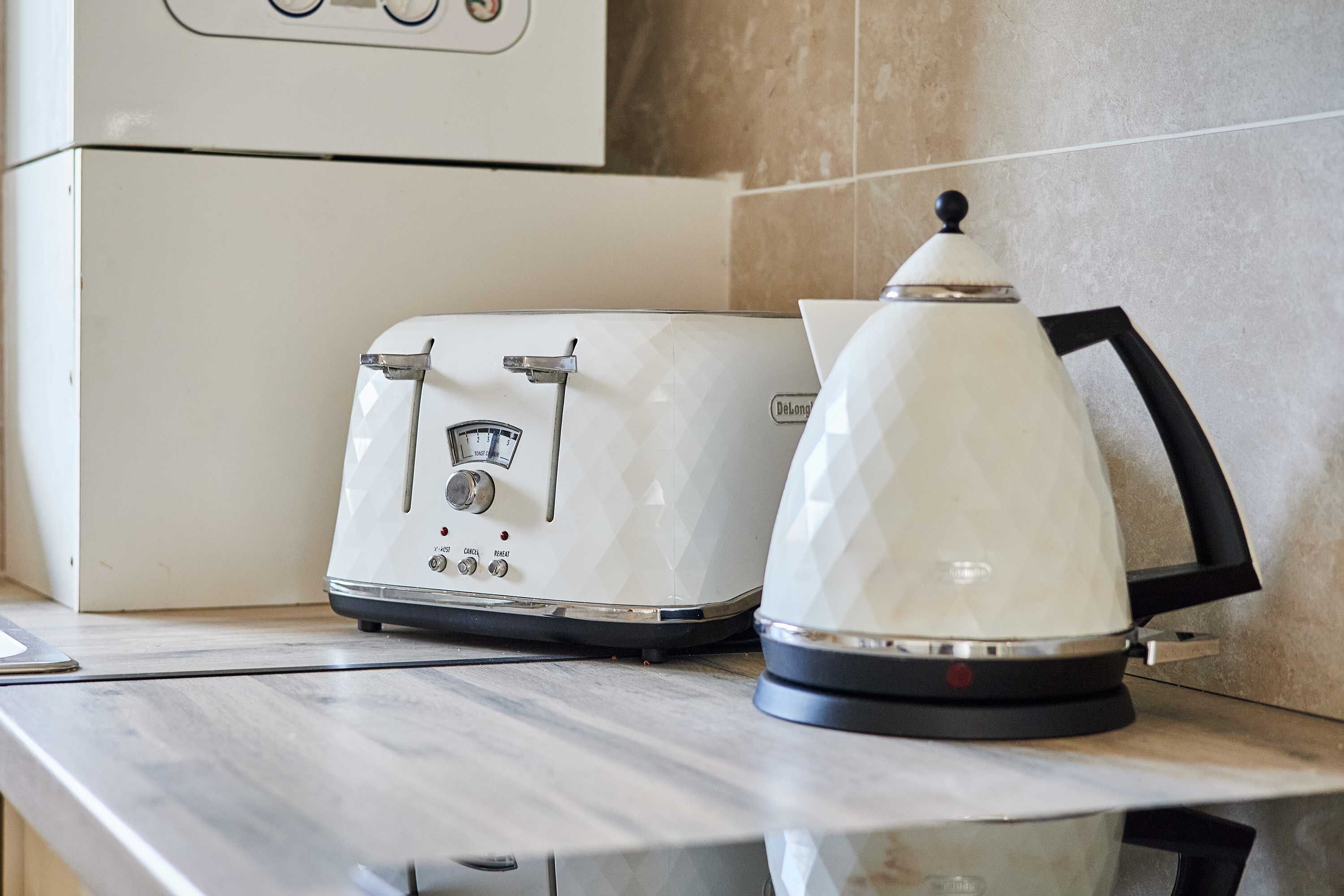 A kitchen counter with a white toaster and a white electric kettle.