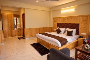 A bedroom with a wooden headboard, a bed with white bedding, a bedside table with a lamp, and a chair. - Echo Homestay (Manali)