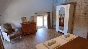 A bedroom with a wooden bed, a dresser, a chair, and a mirror.