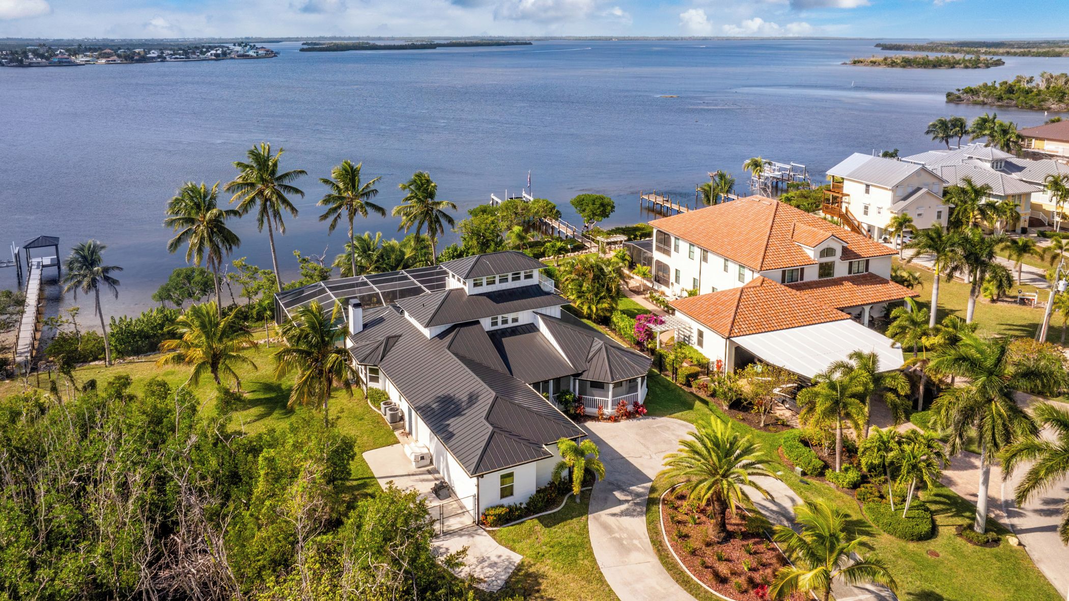 Zona residencial costera con casas, palmeras y un puerto deportivo.