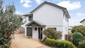 A two-story residential building with a driveway, a front door, and a small porch. - Panorama Bay Escape San Remo (San Remo)