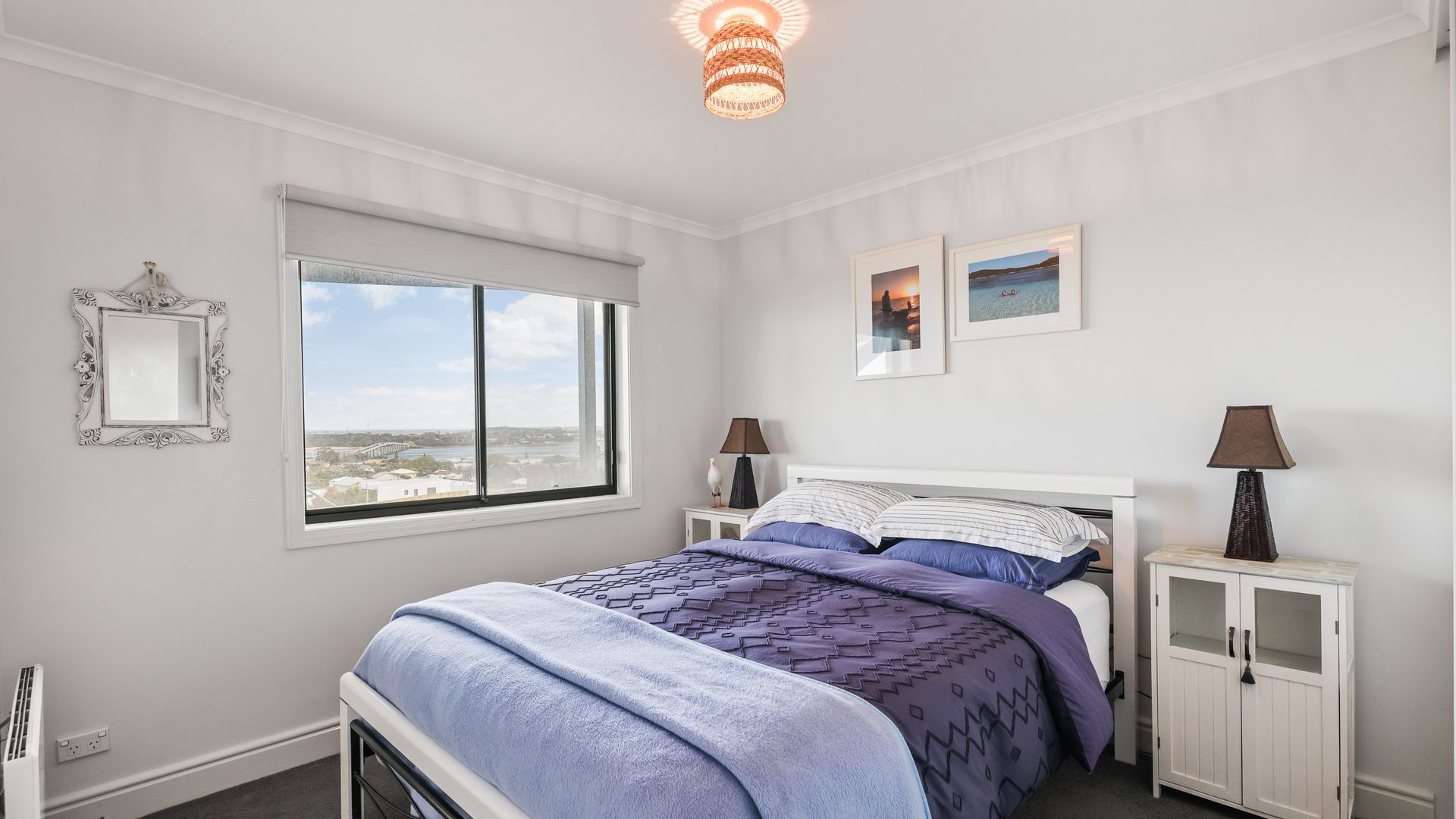 Un dormitorio con cama, una ventana con vistas, una mesita de noche y un armario.
