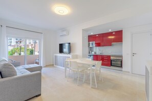 A modern apartment with a living area, a dining space, and a kitchen. - Superior one-bedroom apartment with a view of the garden. (Portimão)