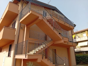 Un immeuble résidentiel à plusieurs étages, doté d’escaliers et de balcons extérieurs.
