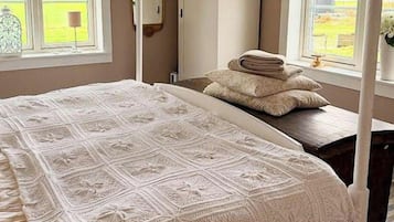 Une chambre avec un grand lit, une armoire et une fenêtre donnant sur un beau paysage.