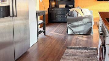 A modern kitchen with a stainless steel refrigerator, wooden cabinets, and a built-in oven.