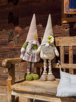 Two gnome figures on a wooden bench with a rustic background.
