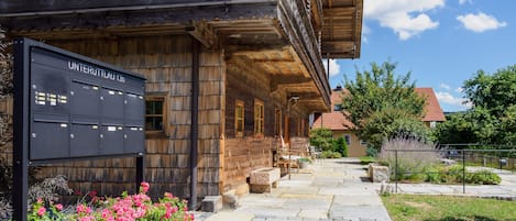 A traditional wooden building with a stone pathway leading to a wooden porch.