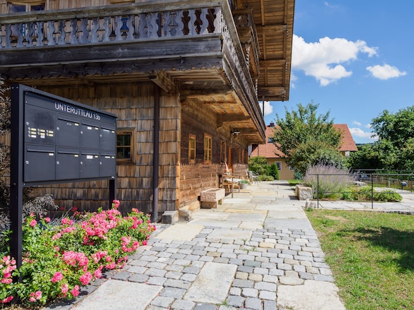 A traditional wooden building with a stone pathway leading to a wooden porch.