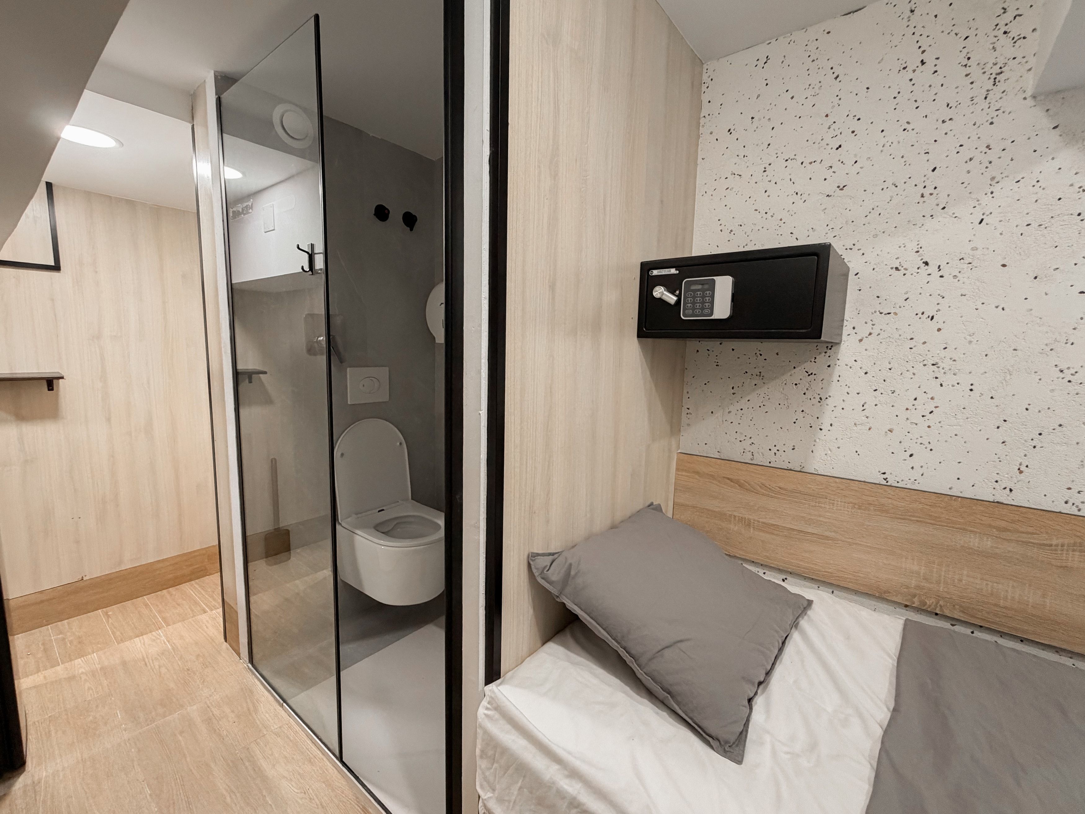 Un baño moderno con ducha envuelta en vidrio, inodoro y toallero de pared.