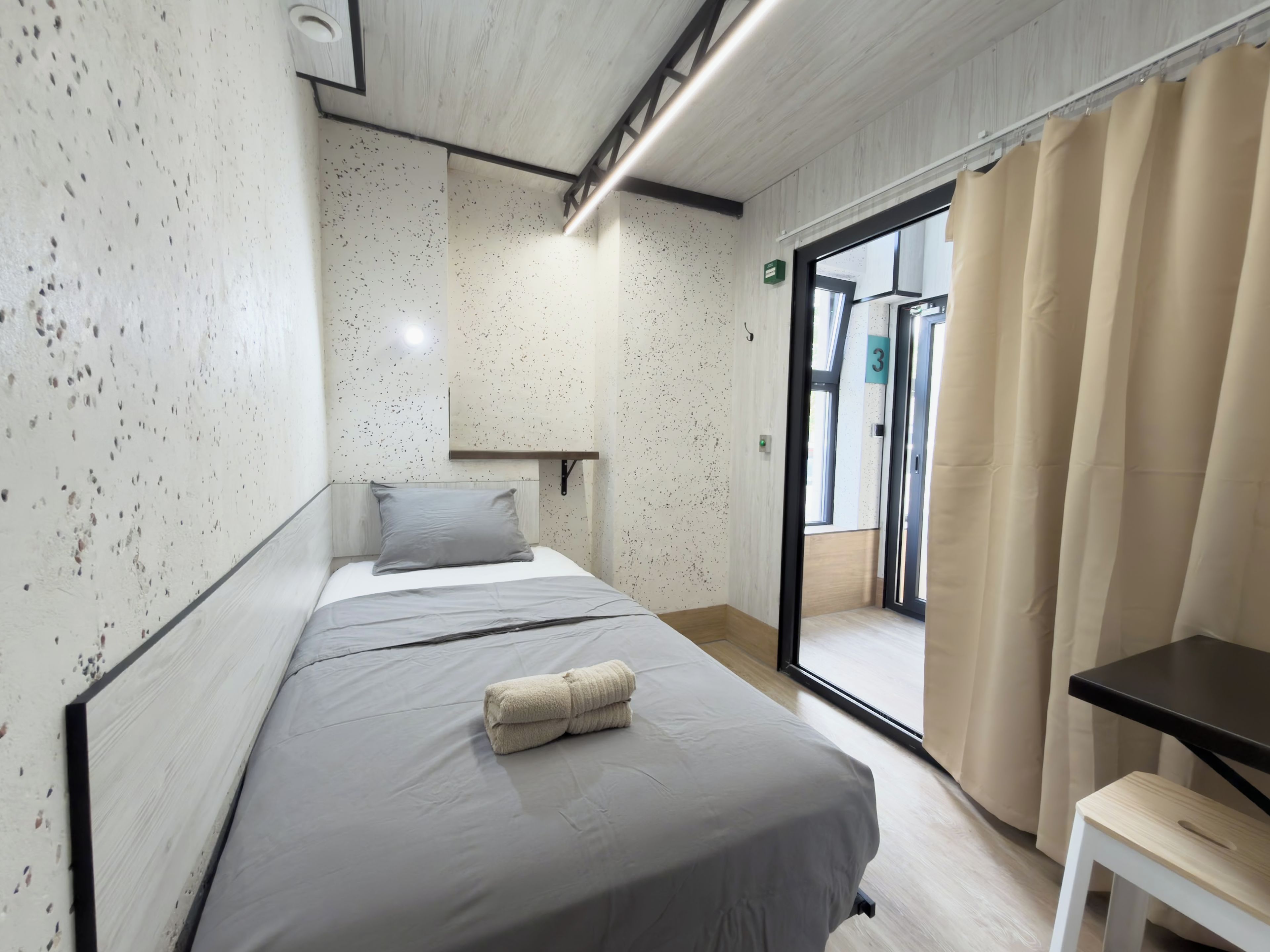 Habitación de hotel moderna con cama, una mesita y vistas al exterior.