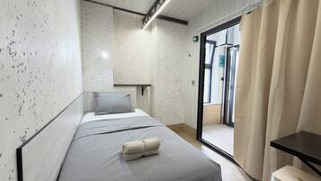 Habitación de hotel moderna con cama, una mesita y vistas al exterior.