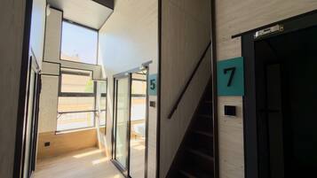 A modern interior with a staircase, glass doors, and wooden flooring.