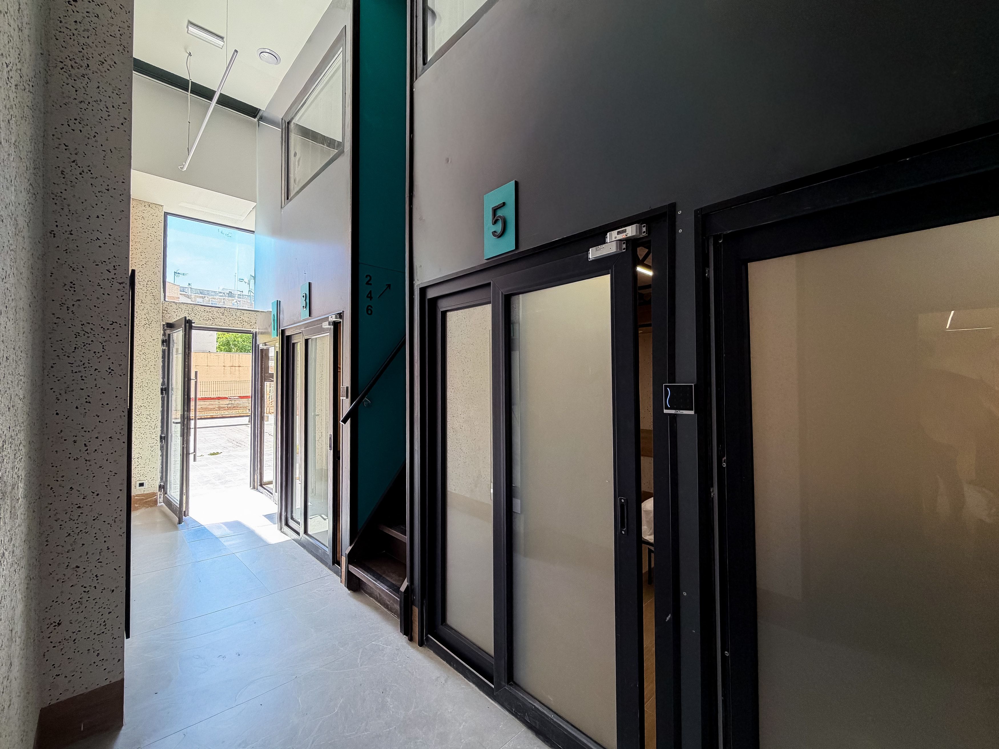 Un couloir avec les portes numérotées 5 et 6, qui donnent accès à des pièces.