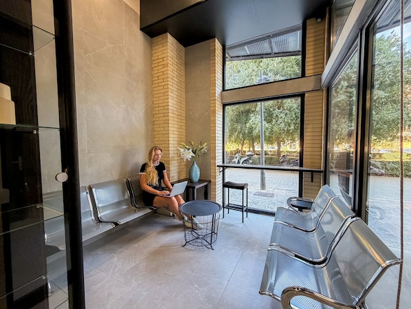 A modern interior with seating, a laptop, and a view of the outdoors.