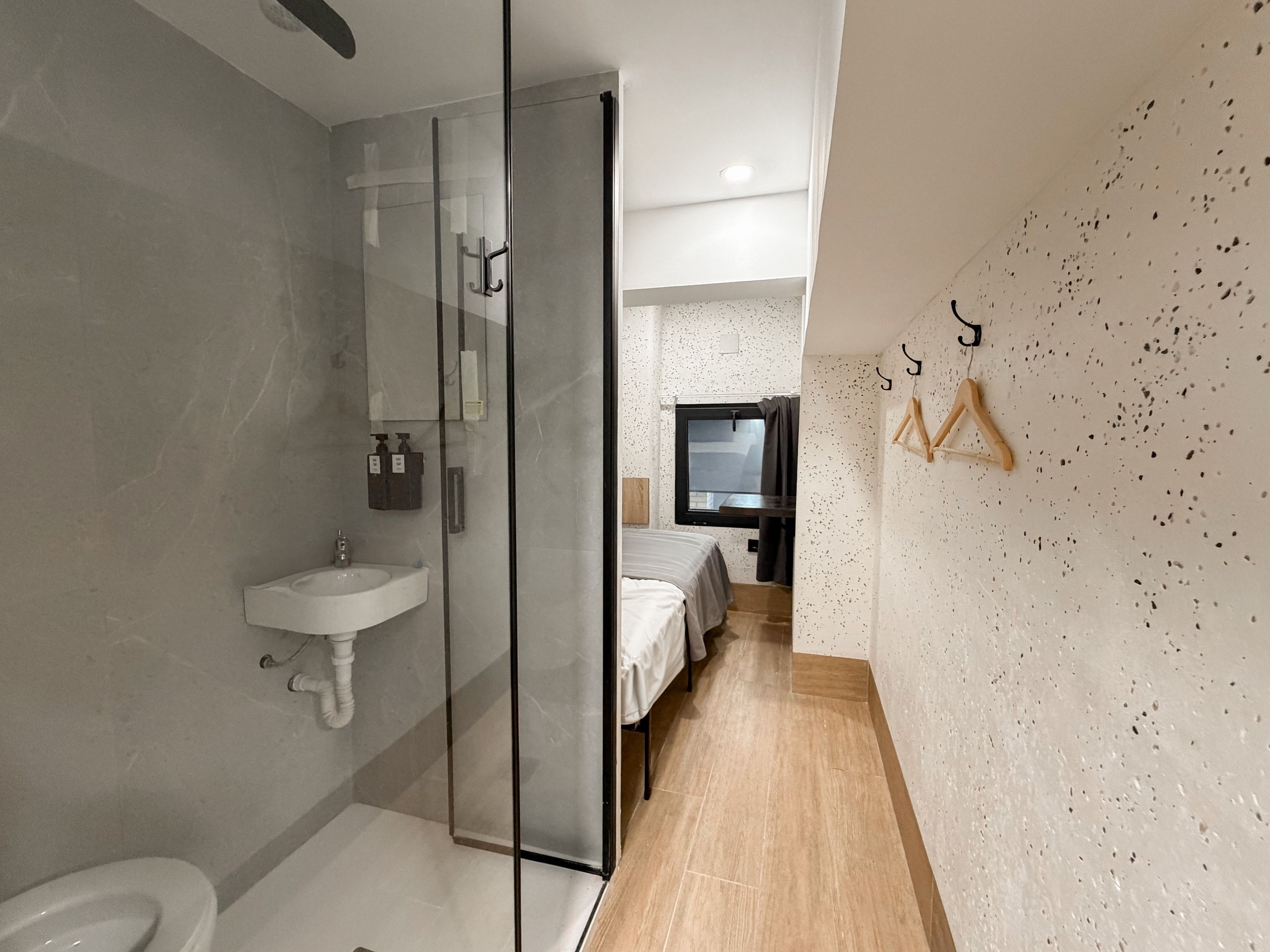 Un baño moderno con cabina de ducha de vidrio, lavabo e inodoro.