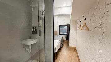 Un baño moderno con cabina de ducha de vidrio, lavabo e inodoro.