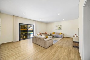 A spacious living room with a large sofa set, a coffee table, and a dining area with chairs. - Villa Casa do Pomar by Villa Plus (Olhos de Água)