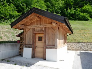A small wooden cabin with a sloped roof, a door, and a window. - Splendid chalet with sauna and mountain views (Tione di Trento)