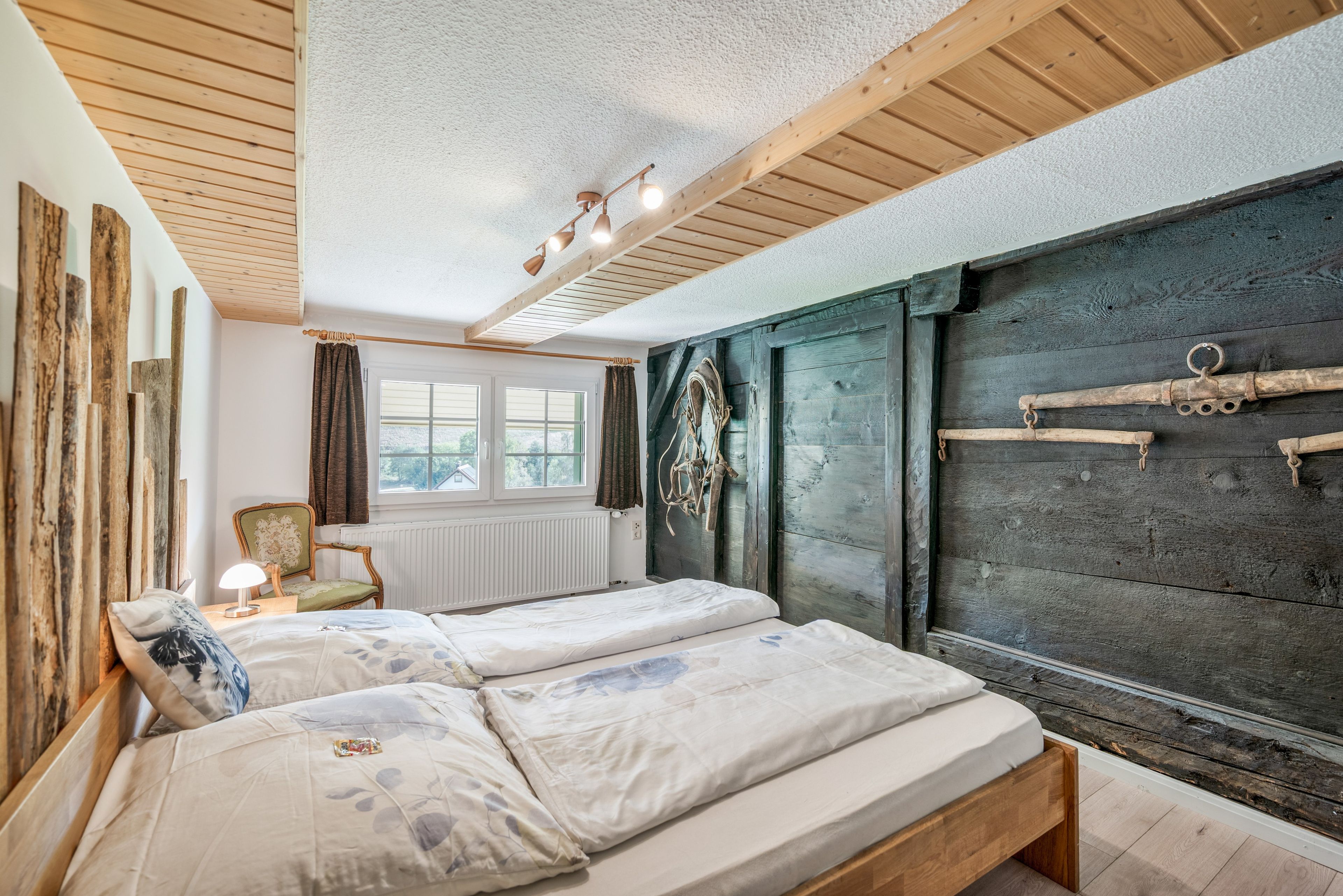 A room with a bed, a chair, a radiator, and a window.