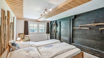 A room with a bed, a chair, a radiator, and a window.
