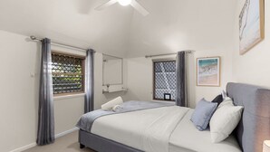 A bedroom with a bed, a ceiling fan, a window with curtains, a bedside table, and a wall-mounted shelf. - Private 2BR Villa | Minutes from Brisbane CBD (Spring Hill)