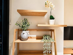 A wooden shelf unit with plants and a decorative item. - Central Fortitude Valley Stay | 1 Bed, 1 Bath (Fortitude Valley)