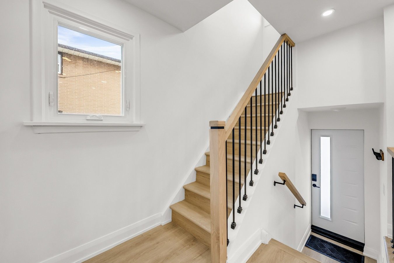 Clean and minimalist design highlighting the staircase with black railing and light wood steps, providing access to the next level.
