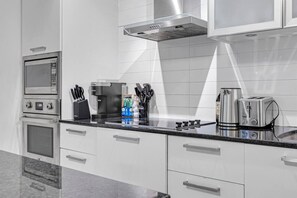A modern kitchen with stainless steel appliances, a coffee maker, and a toaster. - *10/10 Location* 2 BR Downtown Condo with GYM (Toronto)