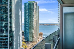 A high-rise building with a view of a body of water and other buildings in the background. - *10/10 Location* 2 BR Downtown Condo with GYM (Toronto)
