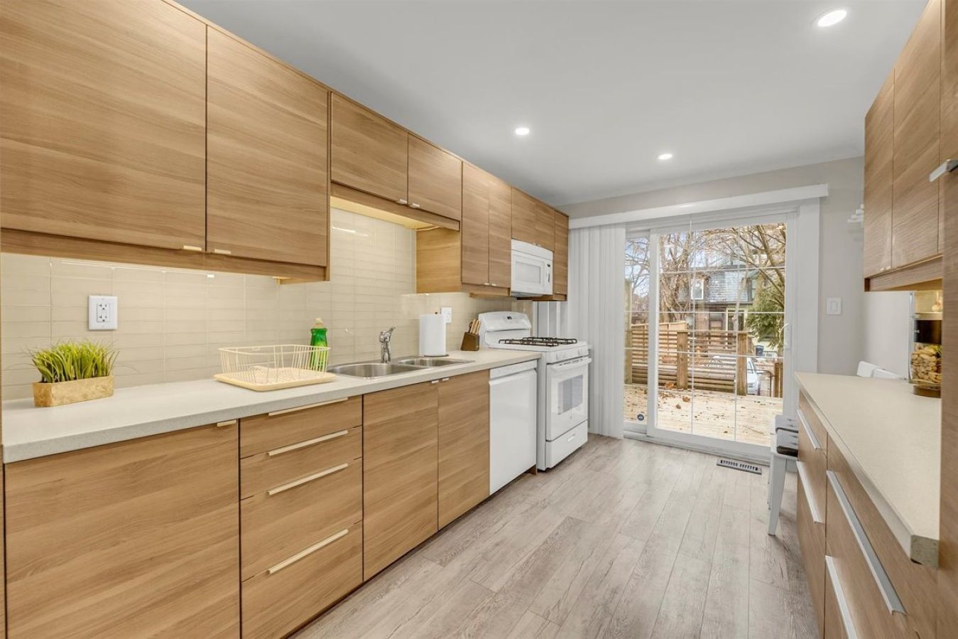 Modern, fully-equipped kitchen with sleek cabinetry and direct access to the back deck.