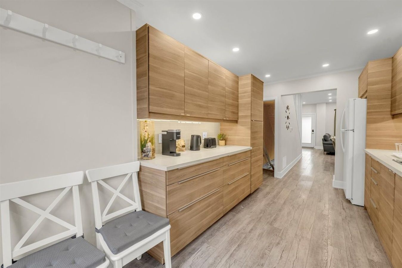 A sleek, wood-finished kitchen featuring clean lines, high-end finishes, and a dedicated coffee station for your morning brew.