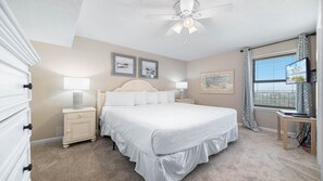 A bedroom with a bed, nightstands, a ceiling fan, and artwork on the walls. - Gorgeous Beachfront 1BR at Phoenix East (Orange Beach)
