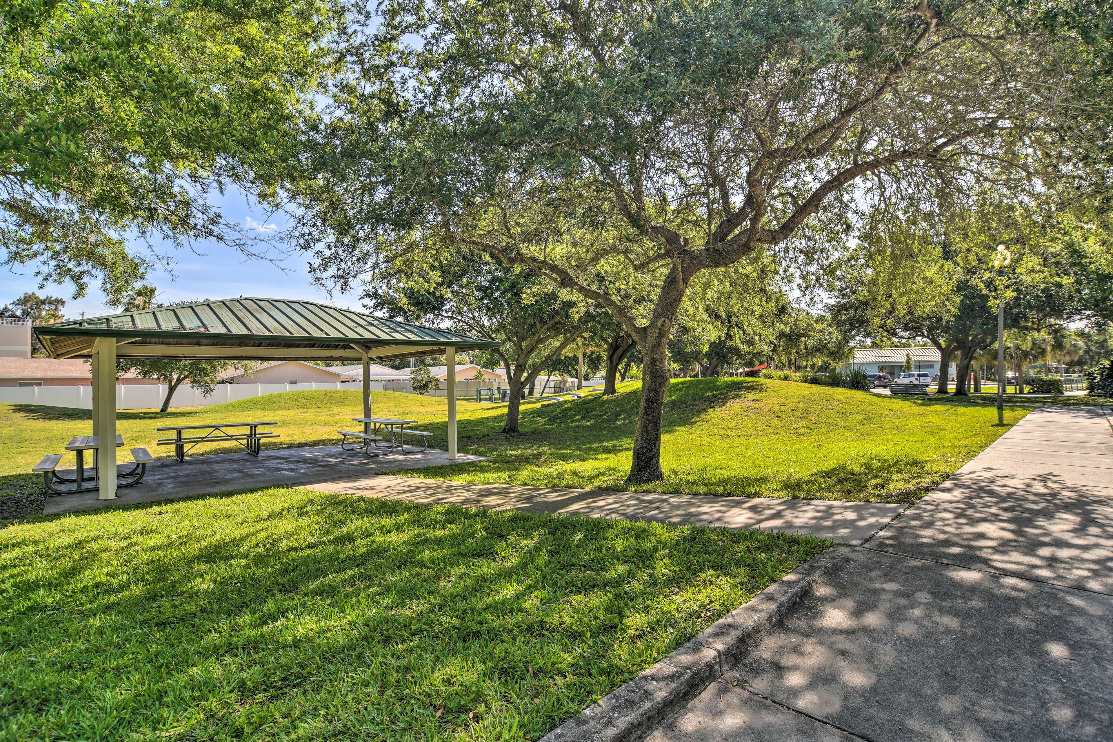 A park with a covered picnic area, benches, and a walking path.