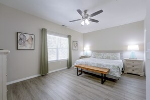 A bedroom with a bed, bedside tables, a ceiling fan, and artwork on the walls. - Condo Near Branson Strip: Close to It All! (Branson)