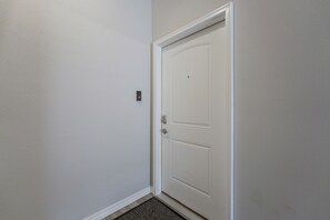 A white door with a doorknob and a small electronic lock on the wall beside it. - Condo Near Branson Strip: Close to It All! (Branson)