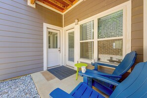 A covered porch with a door, a bench, and a table with two chairs. - Condo Near Branson Strip: Close to It All! (Branson)