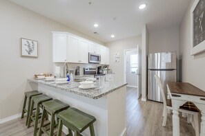 A kitchen with white cabinets, a stainless steel refrigerator, and a granite countertop. - Condo Near Branson Strip: Close to It All! (Branson)