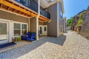 A building with a covered patio area, outdoor seating, and a gravel driveway. - Condo Near Branson Strip: Close to It All! (Branson)