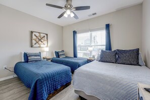 A bedroom with two beds, a ceiling fan, a window with curtains, and a wall-mounted artwork. - Condo Near Branson Strip: Close to It All! (Branson)