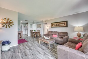 A living room with a brown leather sofa, a wooden coffee table, and a dining area with a wooden table and chairs. - Branson Condo Near Shows, Dining & Table Rock Lake (Branson)