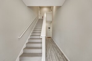 Un escalier avec une rampe, un extincteur et une pancarte de bienvenue.