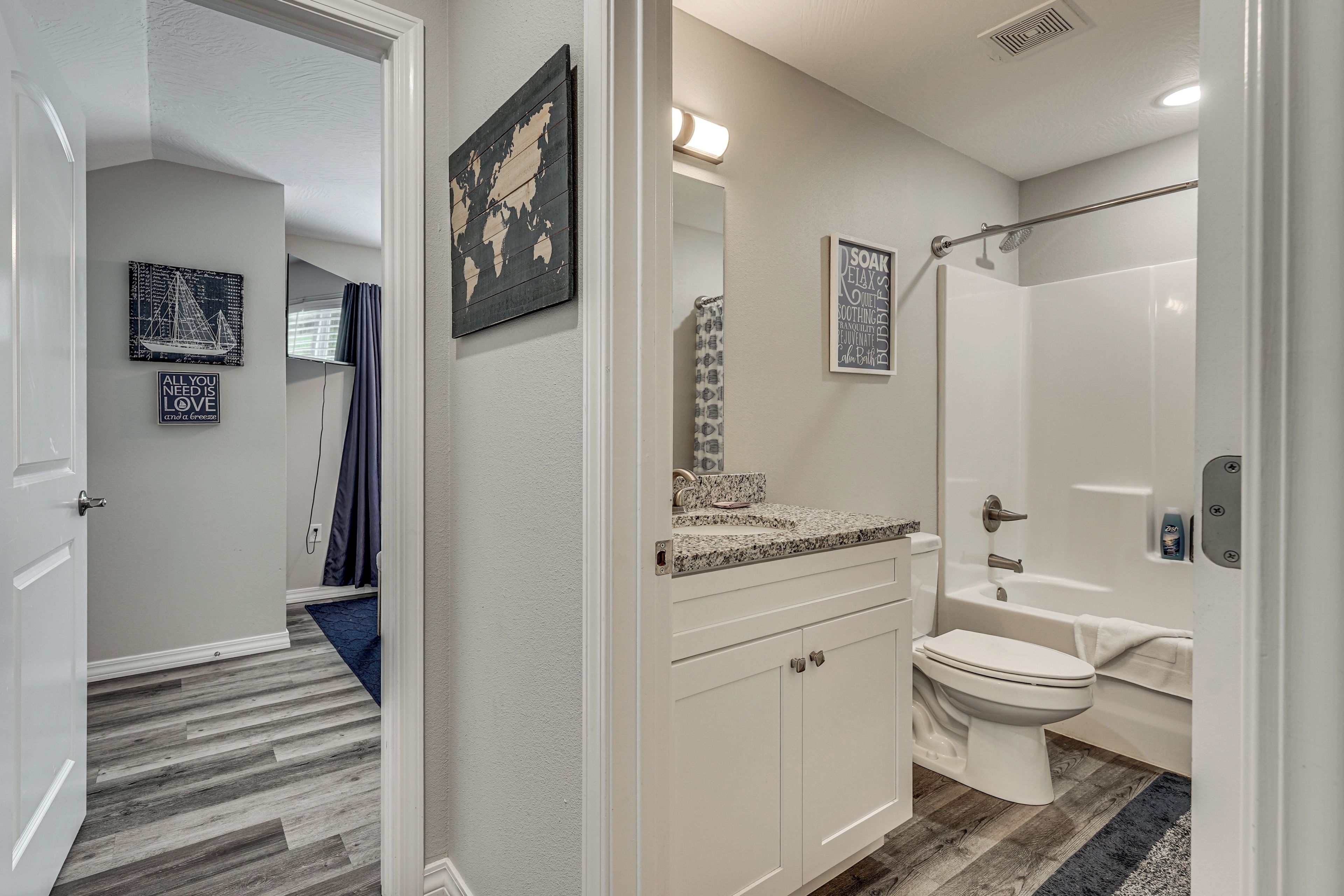 A modern bathroom with a shower, toilet, and sink.