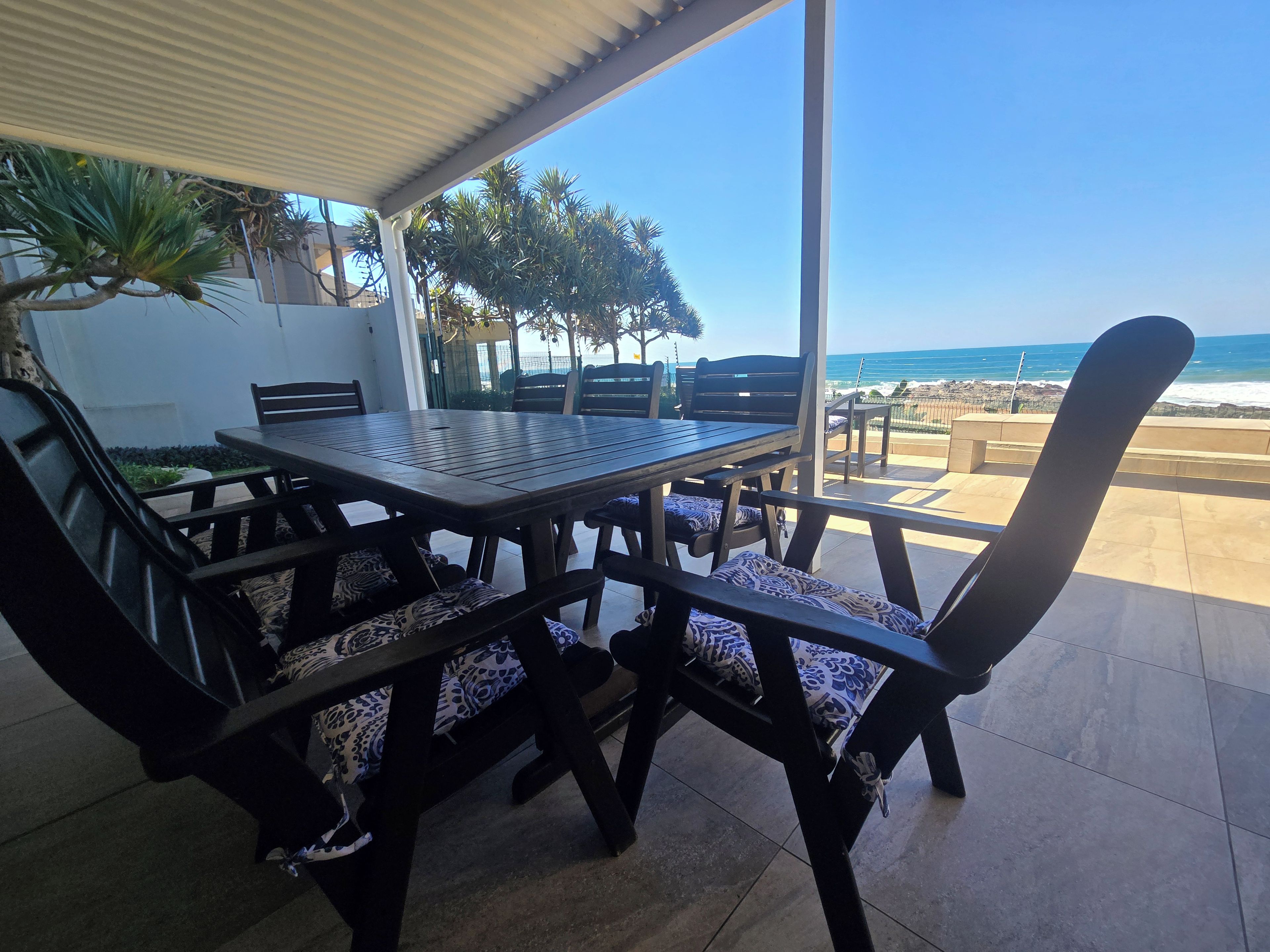 Ein überdachter Essbereich mit Blick auf Strand und Meer.