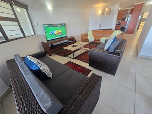A modern living room with a television, sofas, and a coffee table.