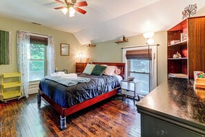 A bedroom with a bed, bedside table, and a wooden dresser.