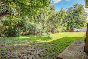 A grassy yard with trees, a wooden deck, and a truck in the background. - Cincinnati-area Condo: Near Shops & Dining (Cincinnati)