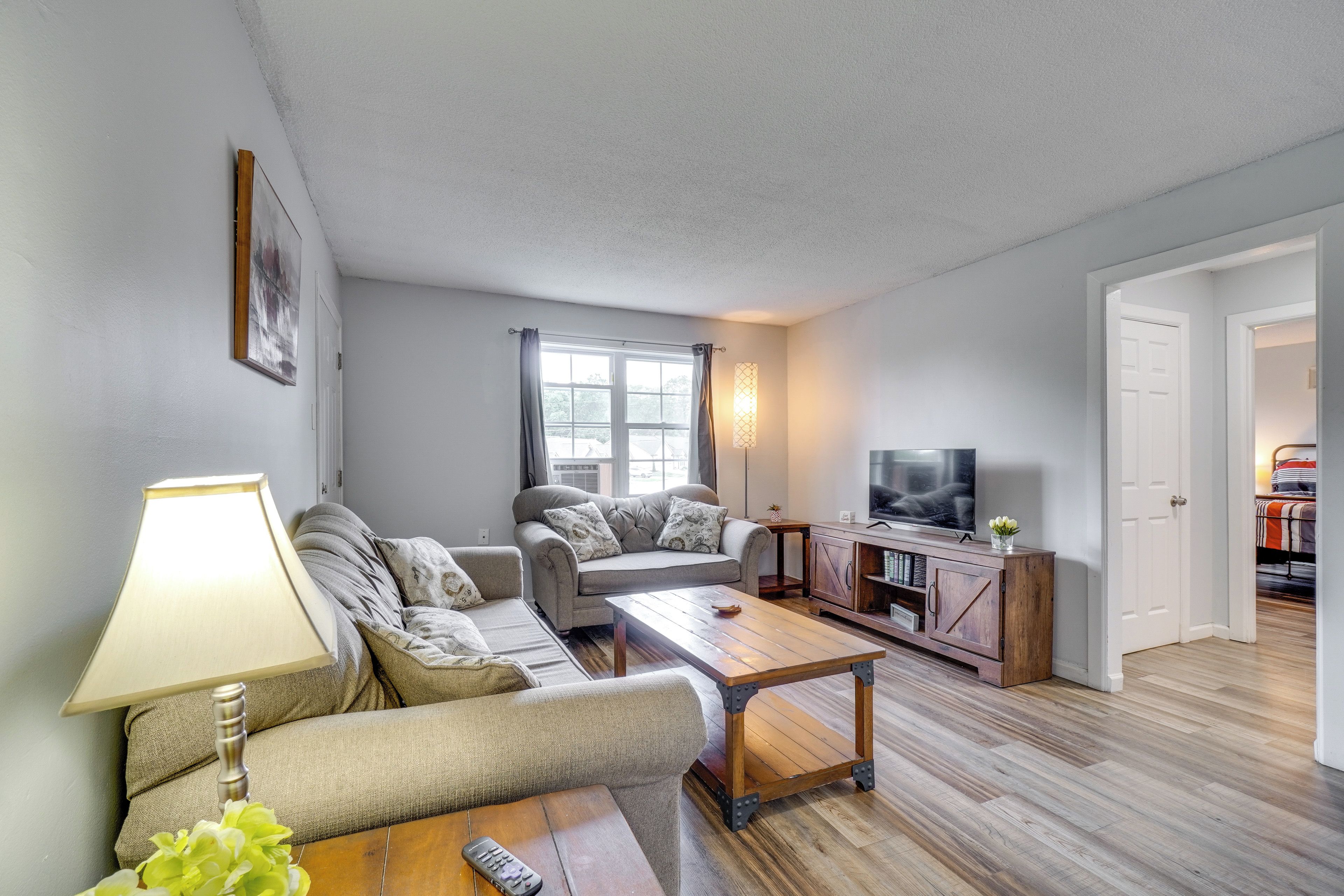 A living room with a sofa set, a coffee table, a TV, and a lamp.