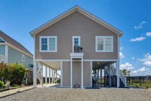A two-story house with a covered porch and a small balcony. - Sunset & Waterway Views! Holden Beach Getaway (Supply)