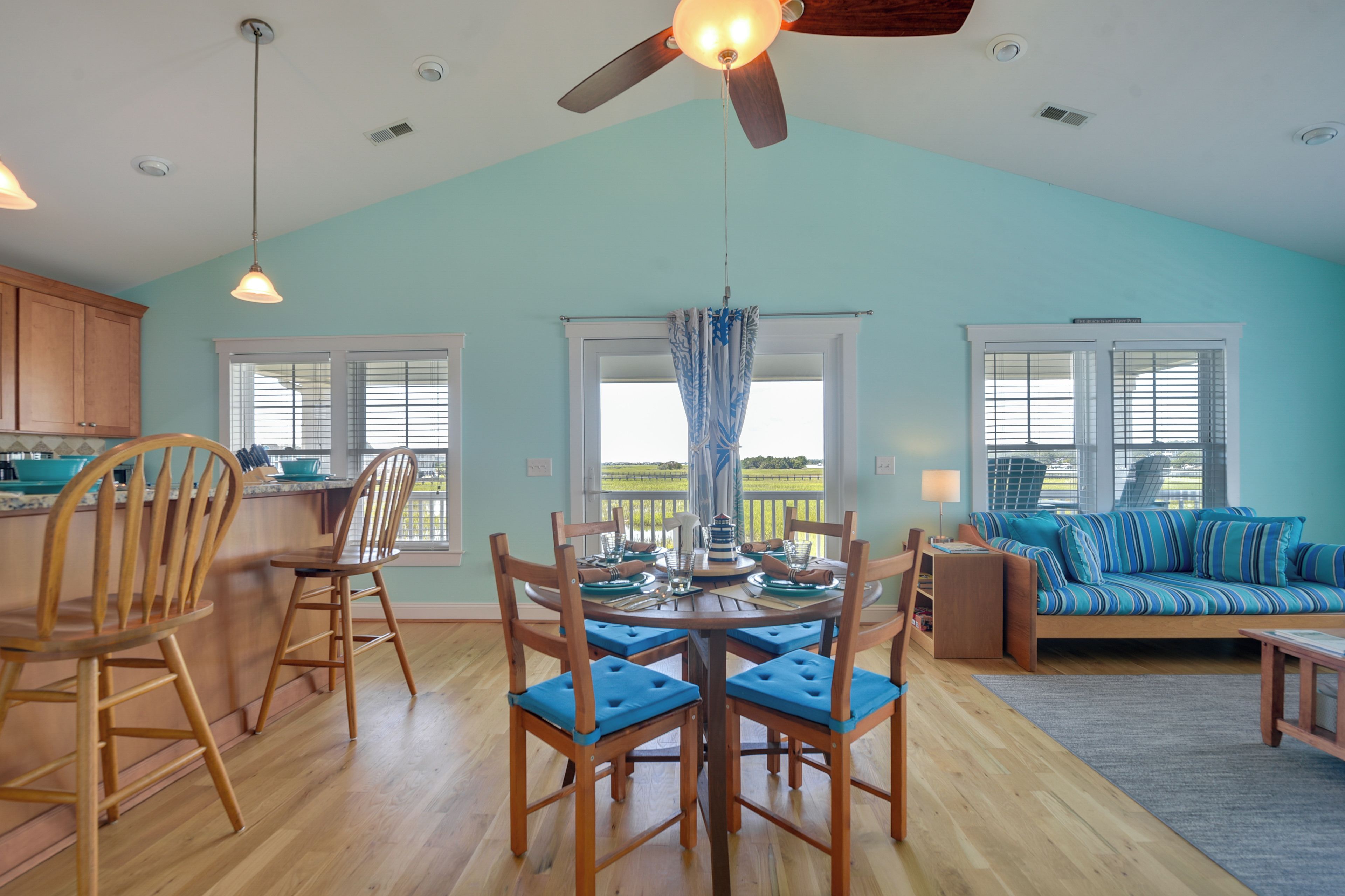 A spacious room with a dining area, a sofa, and a view of the outdoors.